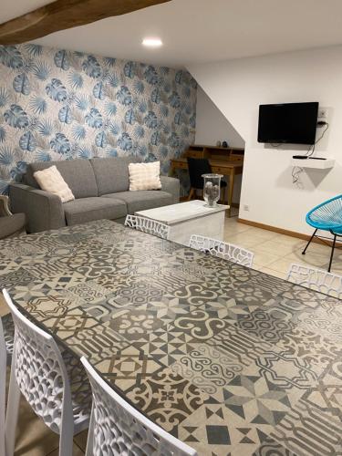 un salon avec une table et un canapé dans l'établissement Les rives du Lay gîte Charette, à Le Boupère