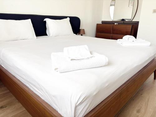 Una cama con toallas blancas encima. en DakarByDays-DBD003-Appartement Adèle 1 chambre, en Dakar
