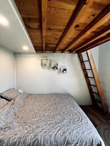 Ce lit se trouve dans une chambre dotée d'un plafond en bois. dans l'établissement Perpignan Appartement T2 Proche Gare 5 Couchages Climatisé, à Perpignan