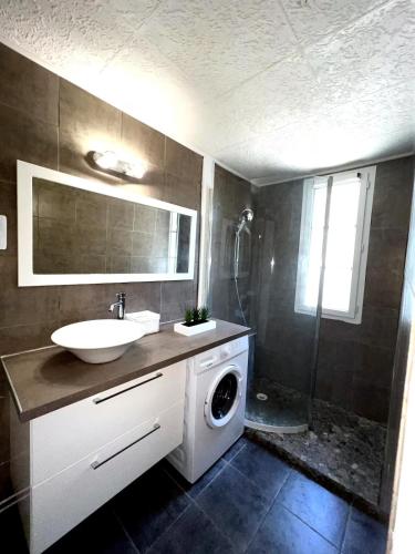 une salle de bain avec une machine à laver et un lavabo dans l'établissement Perpignan Appartement T2 Proche Gare 5 Couchages Climatisé, à Perpignan