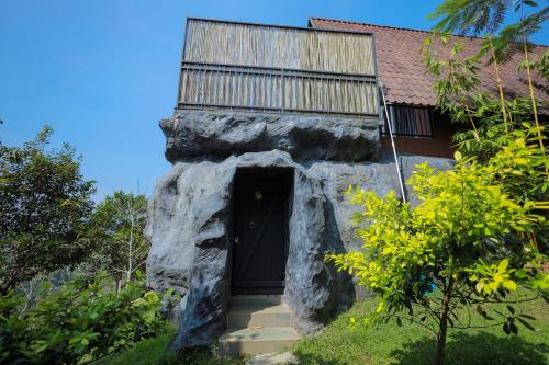 a rock house with a black door and a balcony at Kap Korome Village Resort in Koroth