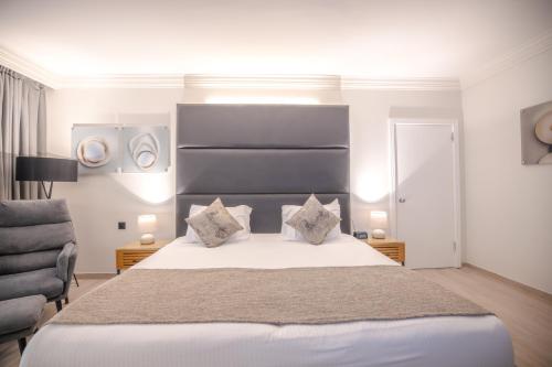 a bedroom with a large white bed with two pillows at David Dead Sea Resort & Spa in Ein Bokek