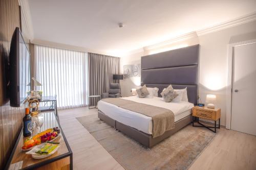 a bedroom with a king sized bed and a table at David Dead Sea Resort & Spa in Ein Bokek