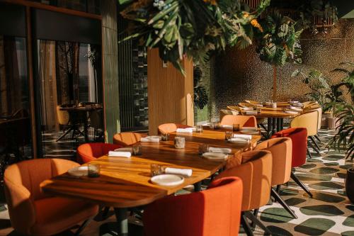 a row of wooden tables and chairs in a restaurant at nhow Amsterdam Rai in Amsterdam