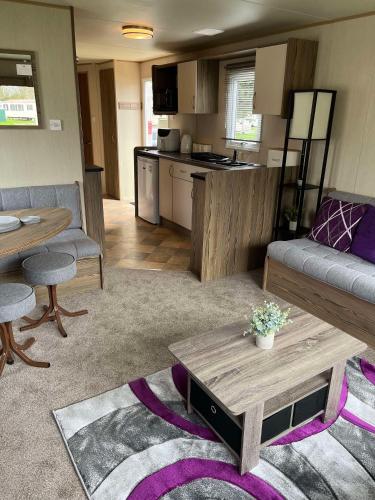 a living room with a couch and a table at 275 - Butlins Skegness, pet friendly and WiFi - Meadow Lakes Caravan & Lodge Hire in Ingoldmells