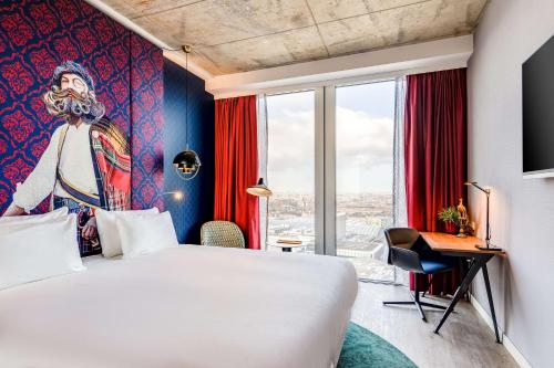 a hotel room with a king sized bed and a painting at nhow Amsterdam Rai in Amsterdam