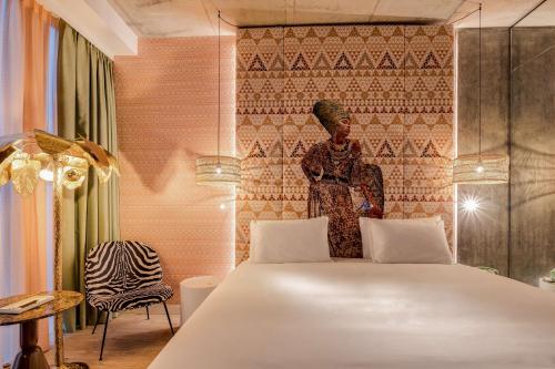 a bedroom with a bed and a statue of a woman at nhow Amsterdam Rai in Amsterdam