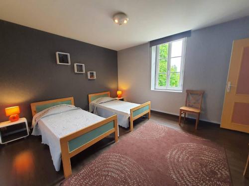 - une chambre avec 2 lits, une fenêtre et un tapis dans l'établissement Location aux portes d'Agen - Clévacances 3 clés, à Saint-Jean-de-Thurac