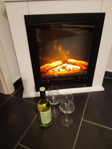 zwei Gläser und eine Flasche Wein vor einem Ofen in der Unterkunft rirodi01 in Gelsenkirchen