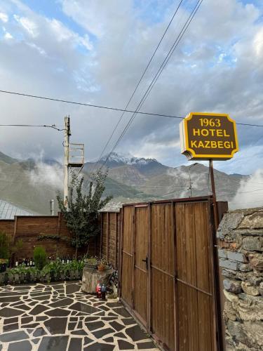 a sign for a hotel next to a fence at HOTEL KAZBEGI 1963 in Stepantsminda