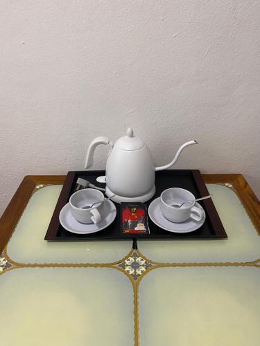 a tea pot and saucers on a tray at PHAI GUESTHOUSE in Luang Prabang