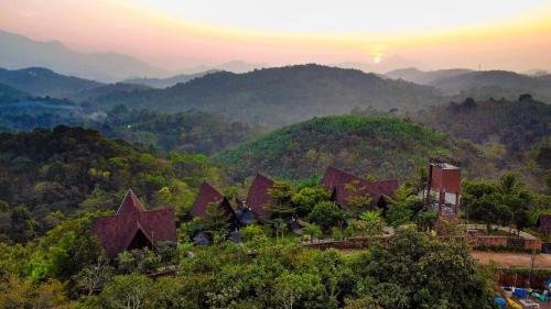 a resort in the mountains with the sun setting in the background at Kap Korome Village Resort in Koroth