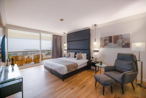 a hotel room with a bed and a chair at David Dead Sea Resort & Spa in Ein Bokek
