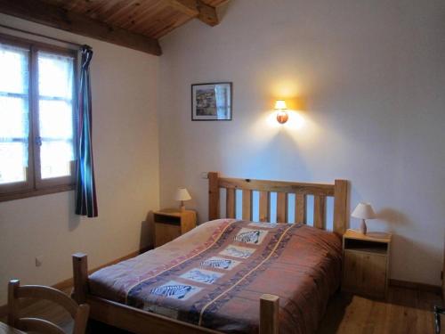 une chambre avec un lit en bois et une fenêtre dans l'établissement Domaine Le Mayne - Le Châtaignier - Clévacances 2 Clés, à Blanquefort-sur-Briolance