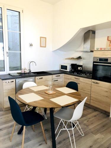 une cuisine avec une table et des chaises en bois dans l'établissement Charmant appartement coeur de centre ville, à Sablé-sur-Sarthe