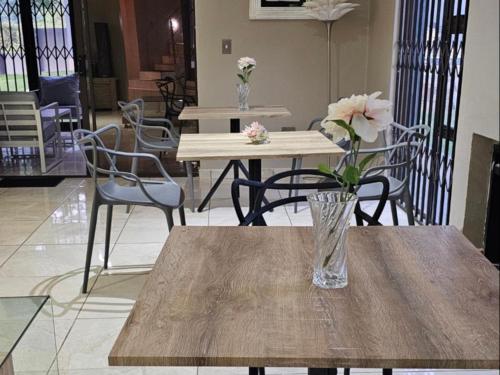 a vase of flowers sitting on a wooden table at Batuka Damview Lodge in Tshakhuma