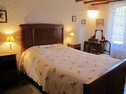 ein Schlafzimmer mit einem großen Bett mit einer weißen Decke in der Unterkunft Ancienne gare rénovée - Clévacances 2 Clés in Réaup