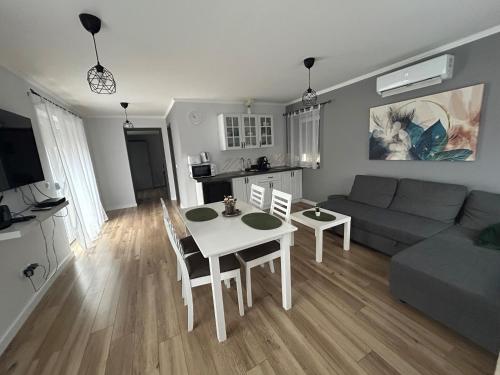 a living room with a table and a couch at Bodza Apartmanház in Harkány