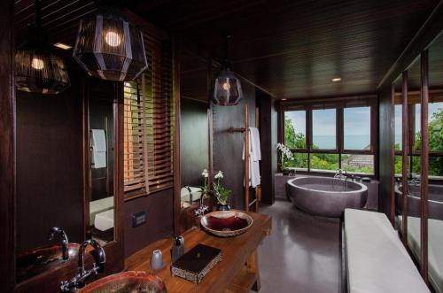 a bathroom with a tub and a sink and a bath tub at Silavadee Pool Spa Resort - SHA Extra Plus in Lamai
