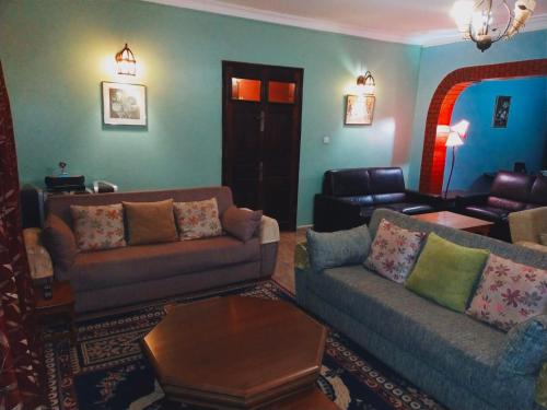 a living room with two couches and a table at Pearl Rangers Inn in Mbale