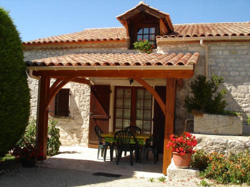 a house with a patio with a table and chairs at Pouchalou - Clévacances 2 Clés in Tournon-dʼAgenais