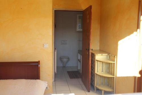 - une chambre avec une porte s'ouvrant sur une salle de bains pourvue de toilettes dans l'établissement VILLA Les Coquelicots GRASSE proche CANNES, à Grasse