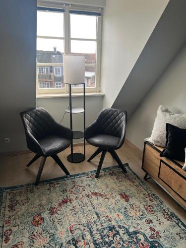 two chairs and a lamp in a living room at Weinhaus Wöhler in Schwerin