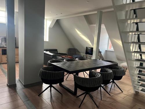 a dining room with a table and chairs and stairs at Weinhaus Wöhler in Schwerin