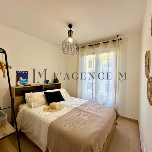 - une chambre avec un grand lit en face d'une fenêtre dans l'établissement Appartement Citadella centre ville & plage CALVI, à Calvi