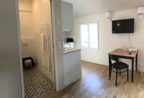 une cuisine avec une table, une petite table, une table et une chaise dans l'établissement Studio 2 new over-equipped Colombes, à Colombes