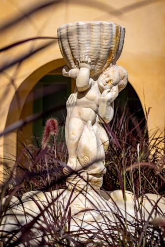 a statue of a cherub carrying a basket on its head at Casa del Sol Suites in Rhodes Town