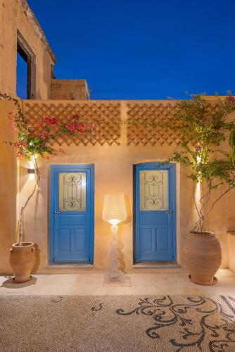 two blue doors on a building with two plants at Casa del Sol Suites in Rhodes Town