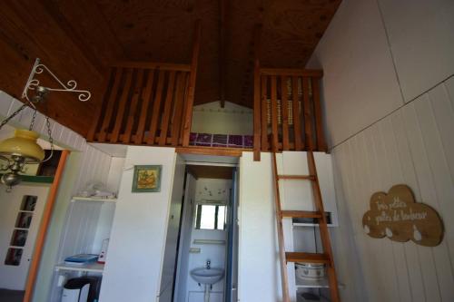 une chambre avec un escalier dans le plafond d'une maison dans l'établissement Petit chalet au Lac de Goulens avec piscine commune - 2 adultes et 1 enfant, à Layrac