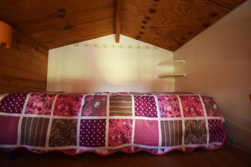 - un lit doté d'une couette dans l'établissement Petit chalet au Lac de Goulens avec piscine commune - 2 adultes et 1 enfant, à Layrac