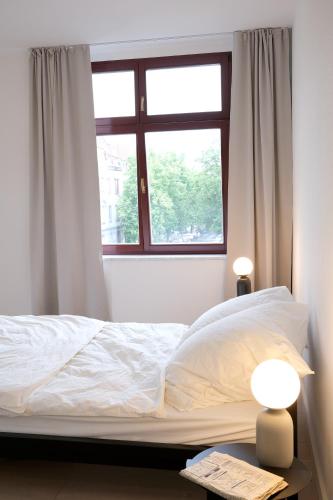 a bedroom with a white bed with a window at Schickes Apartment in Zwickau direkt am Römerplatz in Zwickau