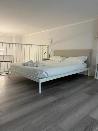 Una cama grande en un dormitorio con suelo de madera. en Corsico Comfort Loft - Affitti Brevi Italia, en Corsico