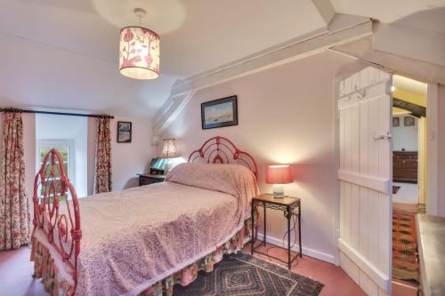 a bedroom with a bed with a pink bedspread at Tan Y Clogwyn in Dolwyddelan