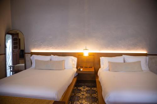 two beds sitting next to each other in a room at DECU DOWNTOWN in Mérida