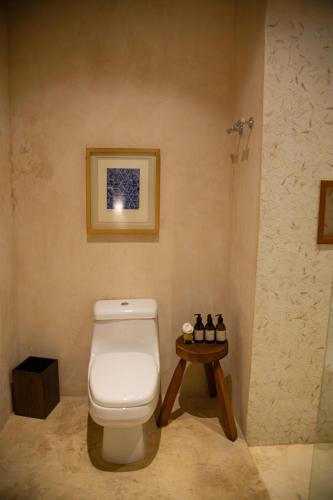 a bathroom with a toilet and a small table at DECU DOWNTOWN in Mérida