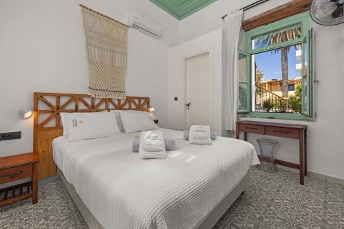 a bedroom with a white bed and a window at Casa del Sol Suites in Rhodes Town
