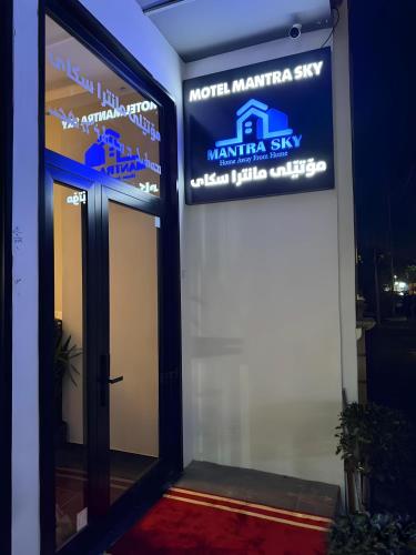 una señal en el lateral de un edificio con una puerta en Mantra Sky Motel, en Erbil