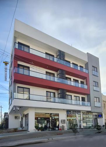 Un edificio alto con rojo y blanco. en Mantra Sky Motel, en Erbil