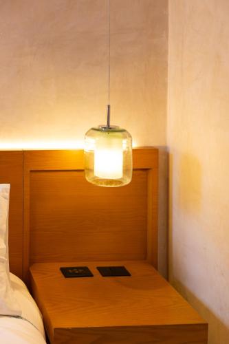 a light hanging over a bed with a wooden table at DECU DOWNTOWN in Mérida