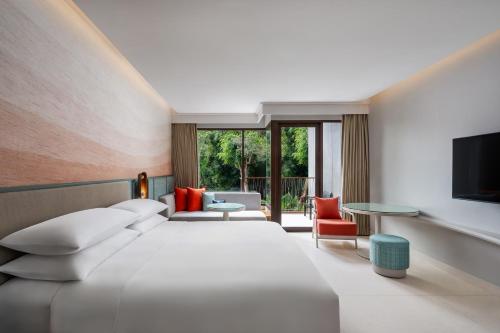 a hotel room with a large bed and a tv at Renaissance Phuket Resort & Spa in Mai Khao Beach