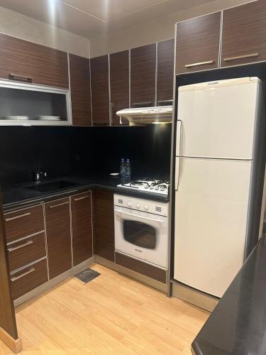 a kitchen with a white refrigerator and a stove at Lahoya Beirut in Beirut