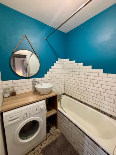 une salle de bain avec une machine à laver et un lavabo dans l'établissement Belle vue à 500m des thermes - climatisé, à Royat