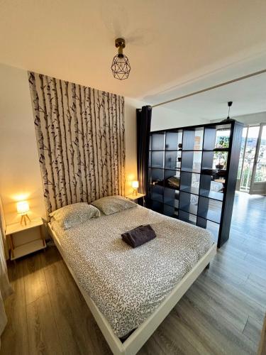 une chambre avec un lit et deux lampes et une fenêtre dans l'établissement Belle vue à 500m des thermes - climatisé, à Royat