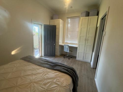 a bedroom with a bed and a window and a desk at Hotel Koorawatha garden unit - ground floor in Koorawatha