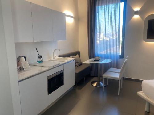 a kitchen with a couch and a table in a room at Gatto Bianco Mia Aparthotel in Milan
