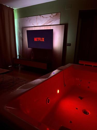 a red bath tub in a room with a tv at Jacuzzi Old Town Escape in Bucharest